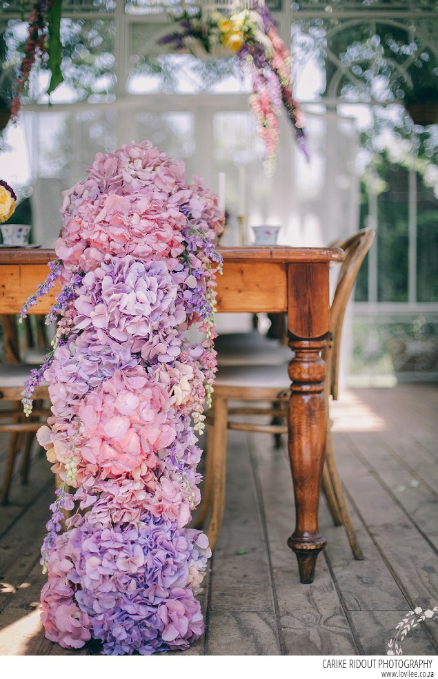 Bridal styled shoot with hydrangea table runner in a greenhouse