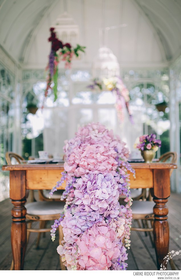 Bridal styled shoot with hydrangea table runner in a greenhouse