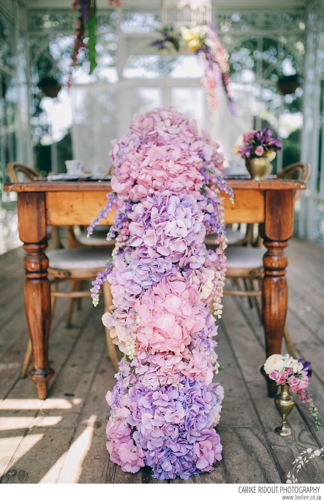 Bridal styled shoot with hydrangea table runner in a greenhouse