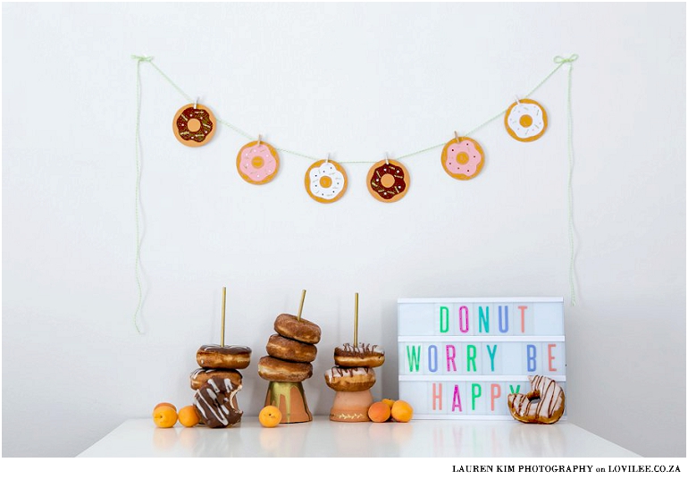 Doughnut candy table set up with DIY paper garland and donut stands