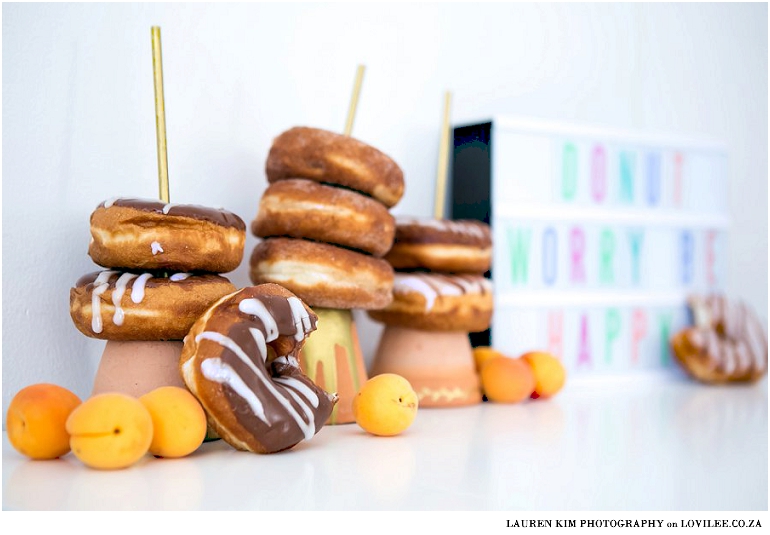 Donut candy table set up with DIY paper garland and donut stands