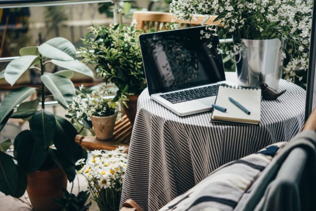 Beautiful terrace or balcony with small table, laptop and flowers Shutterstock stock image By Yulia Grigoryeva