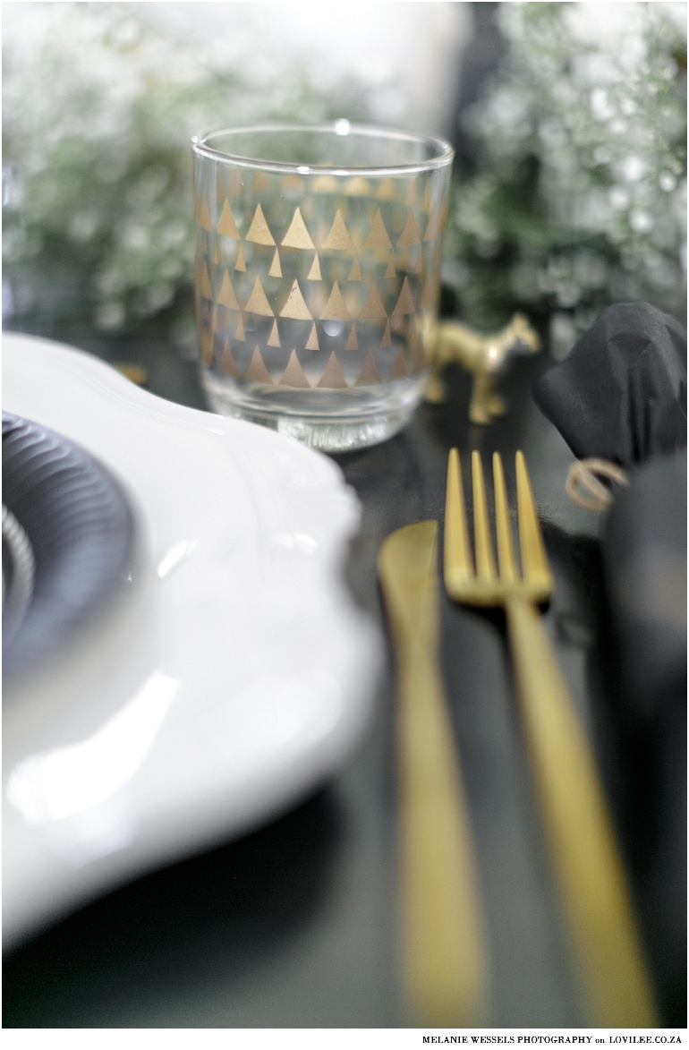 Gold cutlery on a black and white tablescape