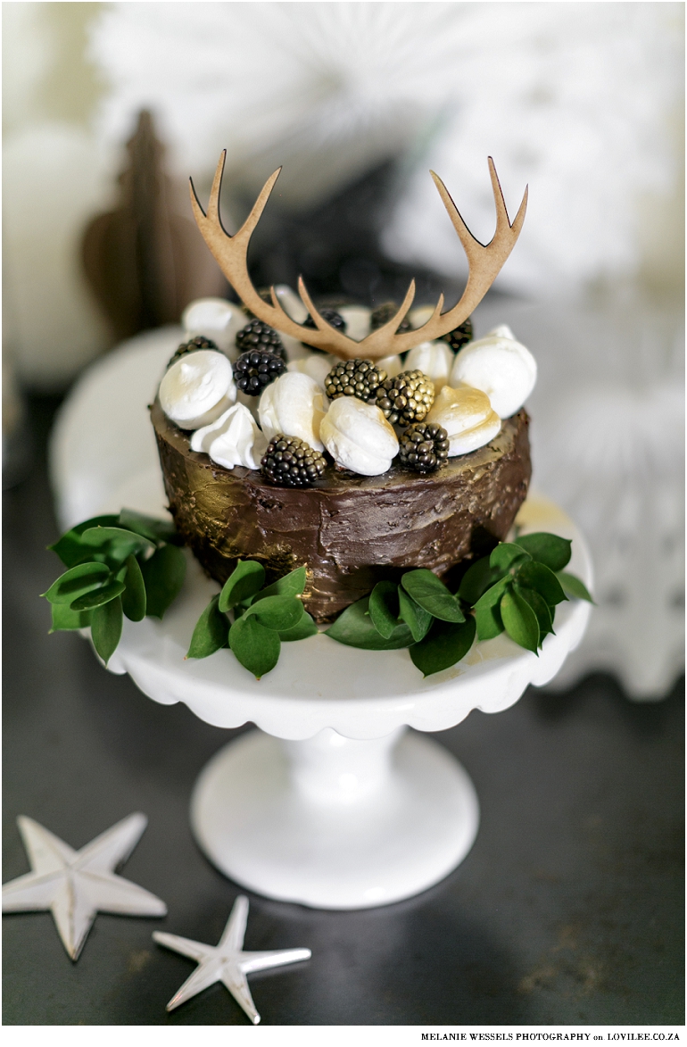 Black and white Christmas table with a Christmas cake and antler cake topper by Lovilee